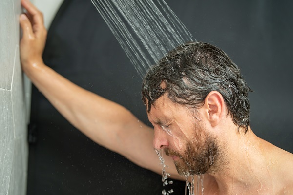 Hombre aclarándose el pelo con agua dulce