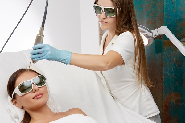 Profesional realizando una terapia con láser a una mujer