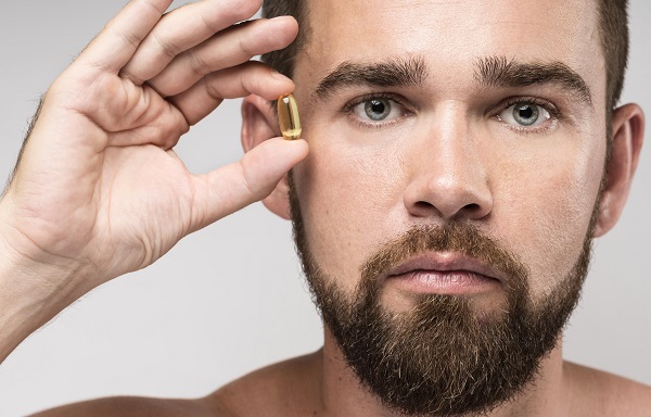 Hombre con suplementos capilares en la mano