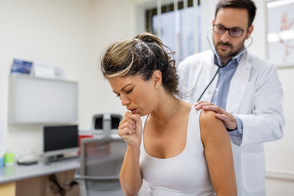 Mujer siendo auscultada por un médico