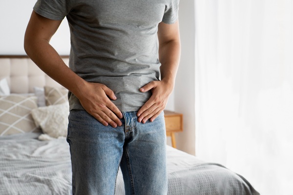 Hombre tocándose la parte de la próstata indicando los problemas que tiene